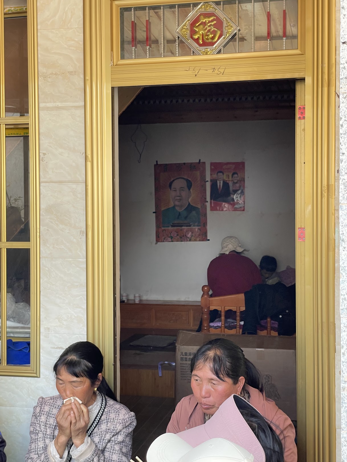 兩位白族女性站在門口旁邊的「福」字